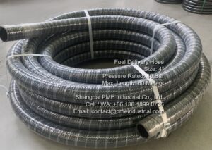 Coiled rolls of 4-inch 40 bar NBR rubber fuel suction and discharge hose in factory warehouse, ready for packaging.